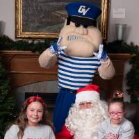 Two girls with Santa and Louie the Laker.